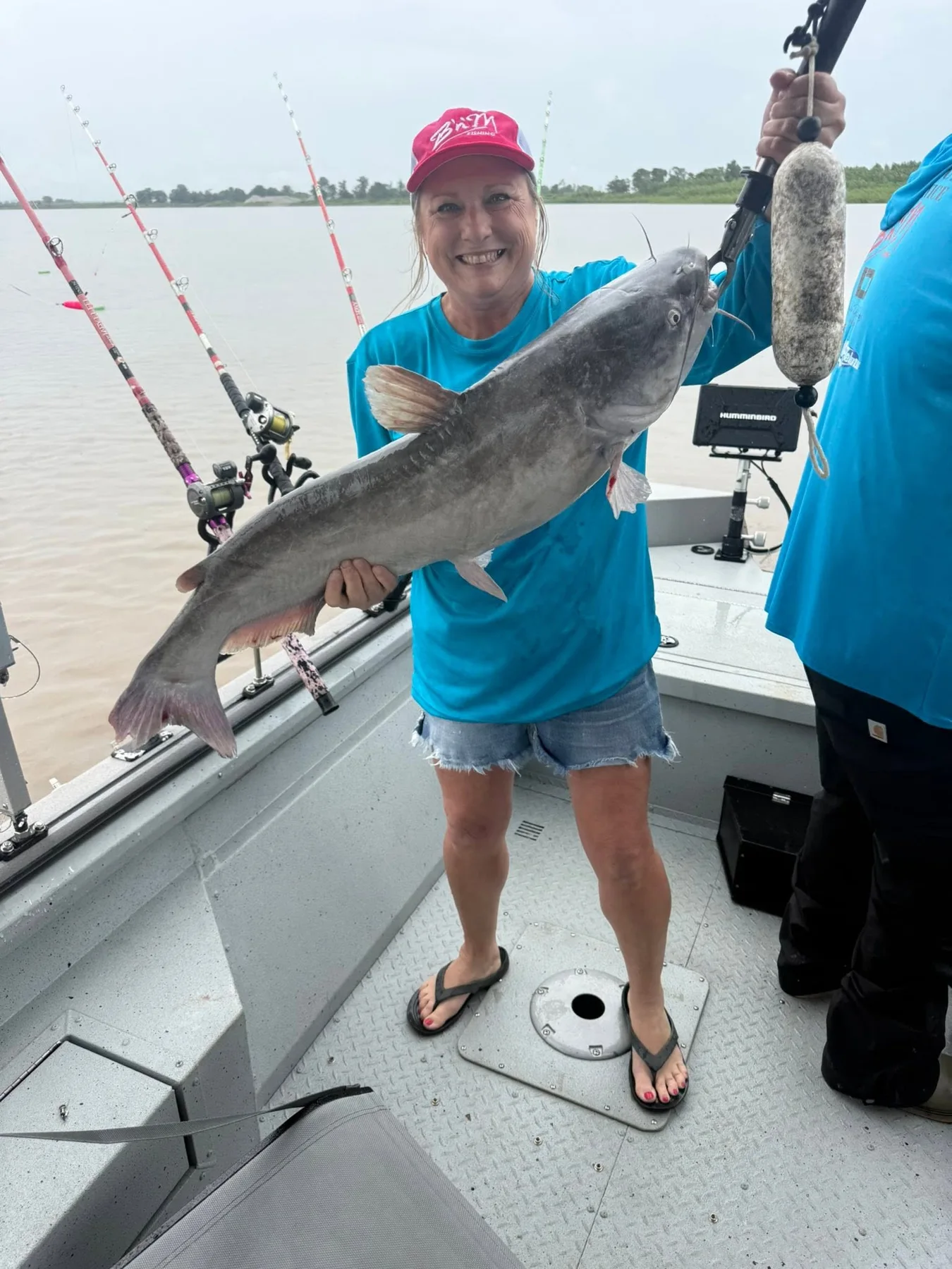 A guest holding a catfish aboard the boat