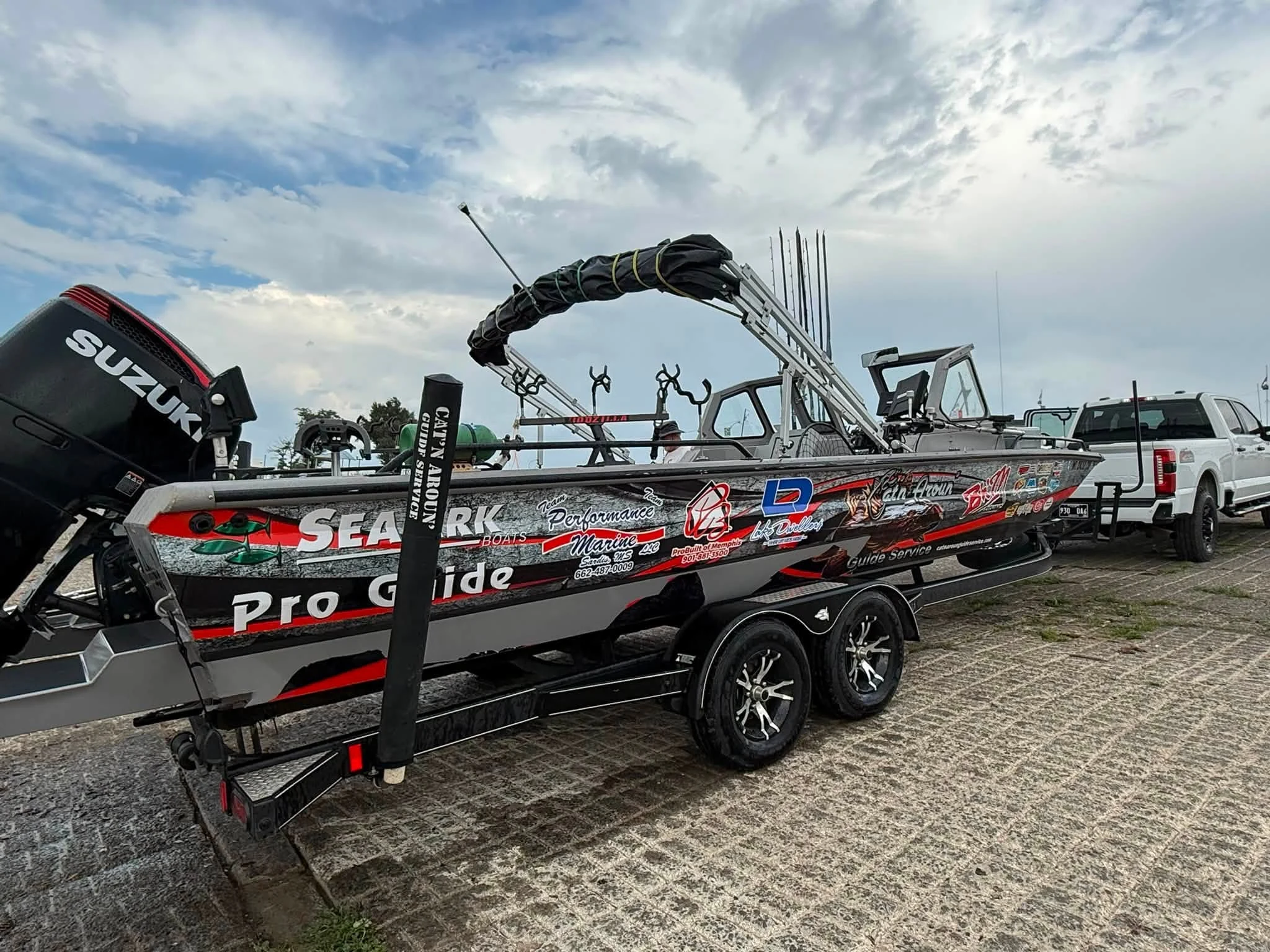 Side profile of Captain Dave’s SeaArk Pro Guide with a Suzuki outboard, rod holders, windshield, and folding canopy