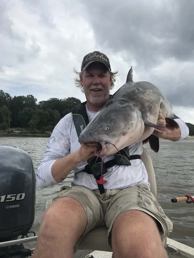 Captain Dave seated with a large catfish